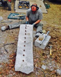 Holes drilled and feather wedges installed in granite slabs
