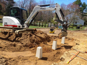 Excavator installing footings
